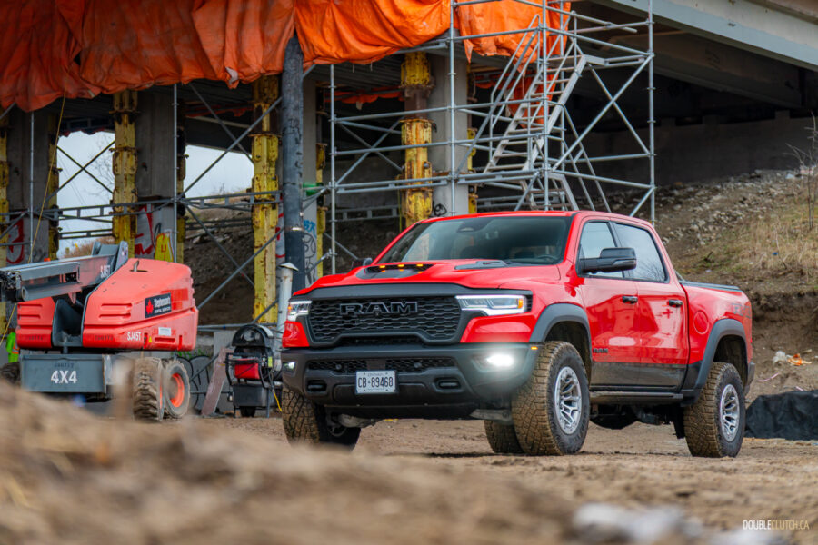 Front quarter view of a red 2025 Ram 1500 RHO, parked in a muddy construction site